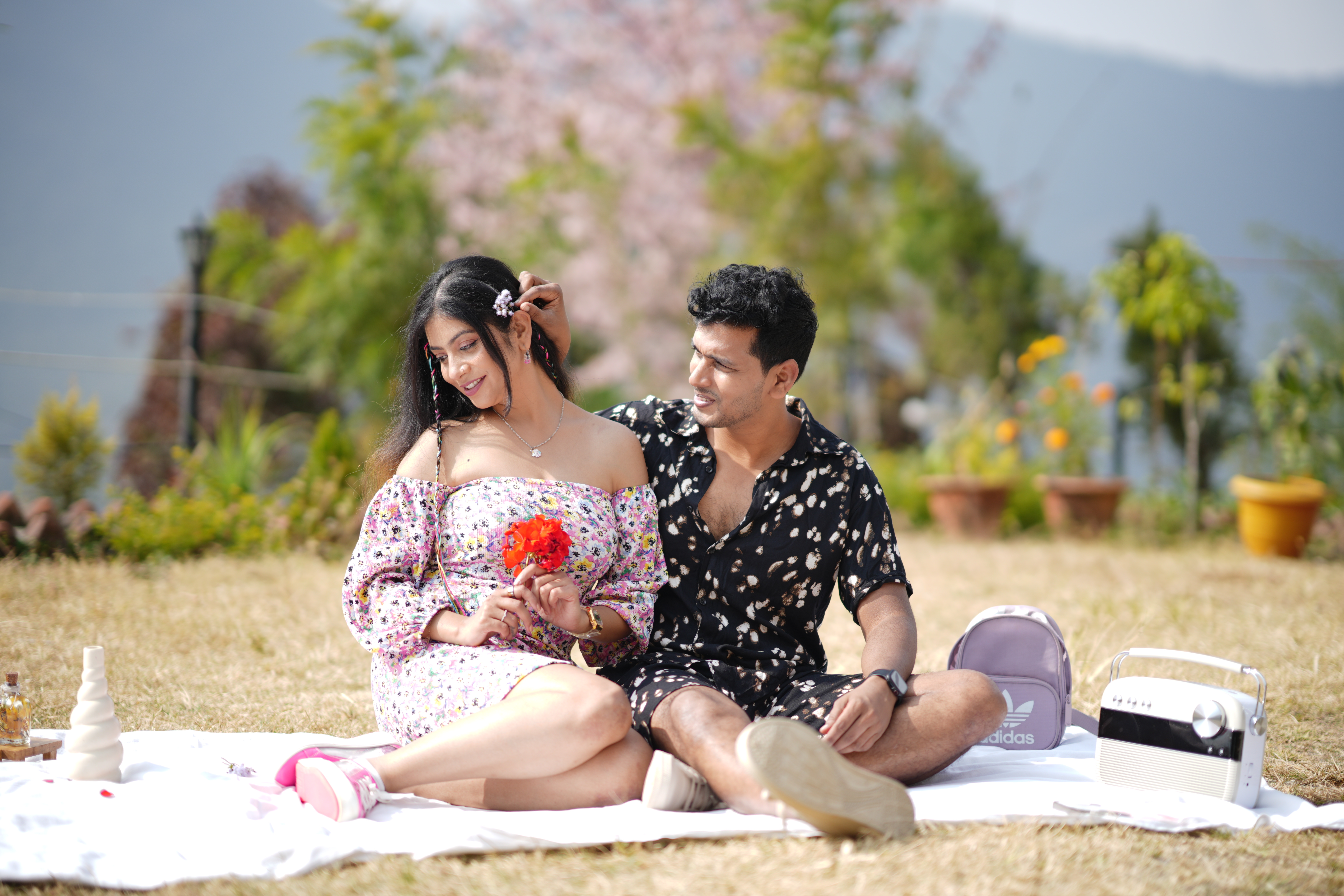 Shy yet romantic moment in garden picnic captured during couple photoshoot